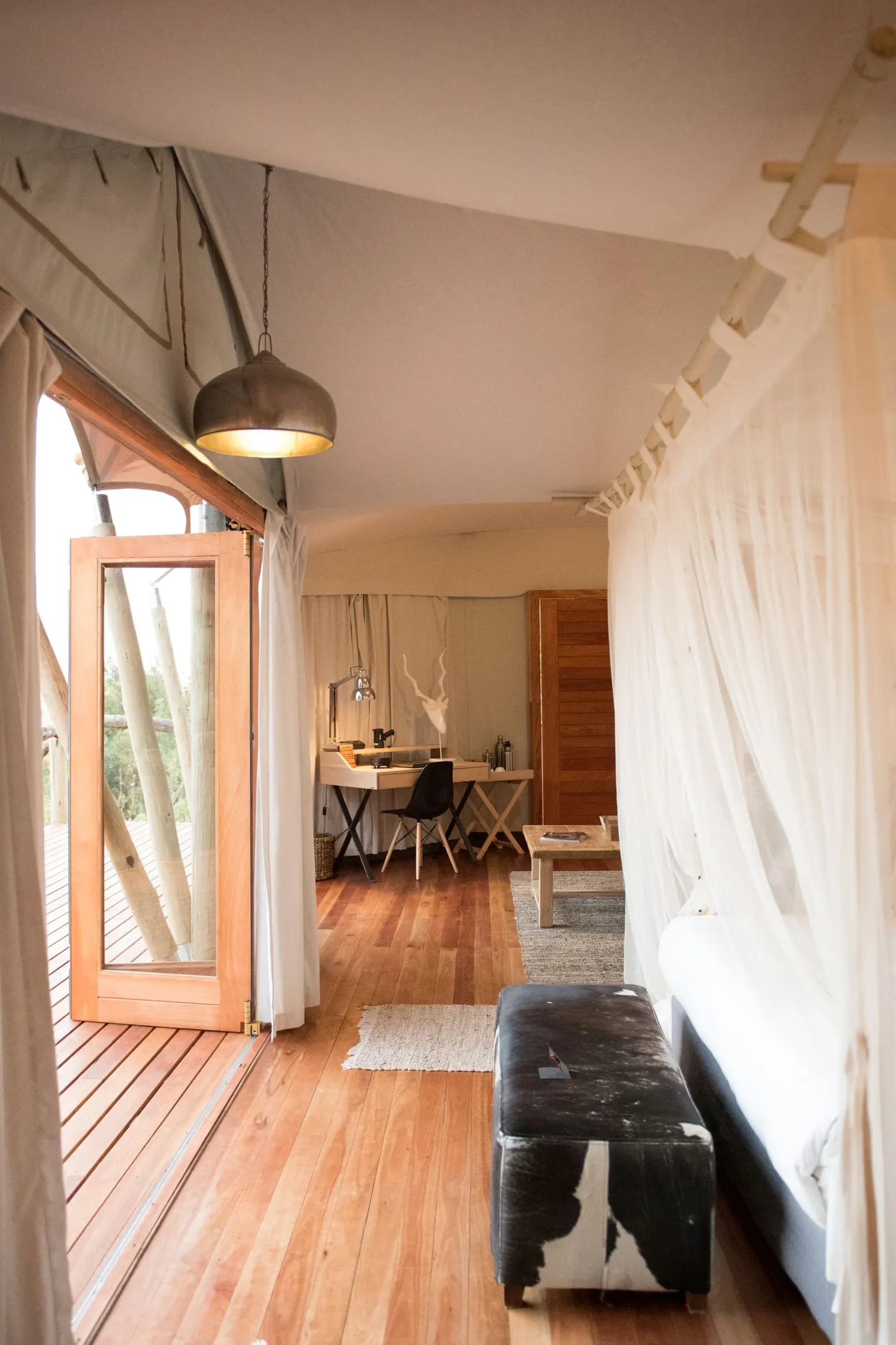 A canvas tented suite interior with timber floors and daybed