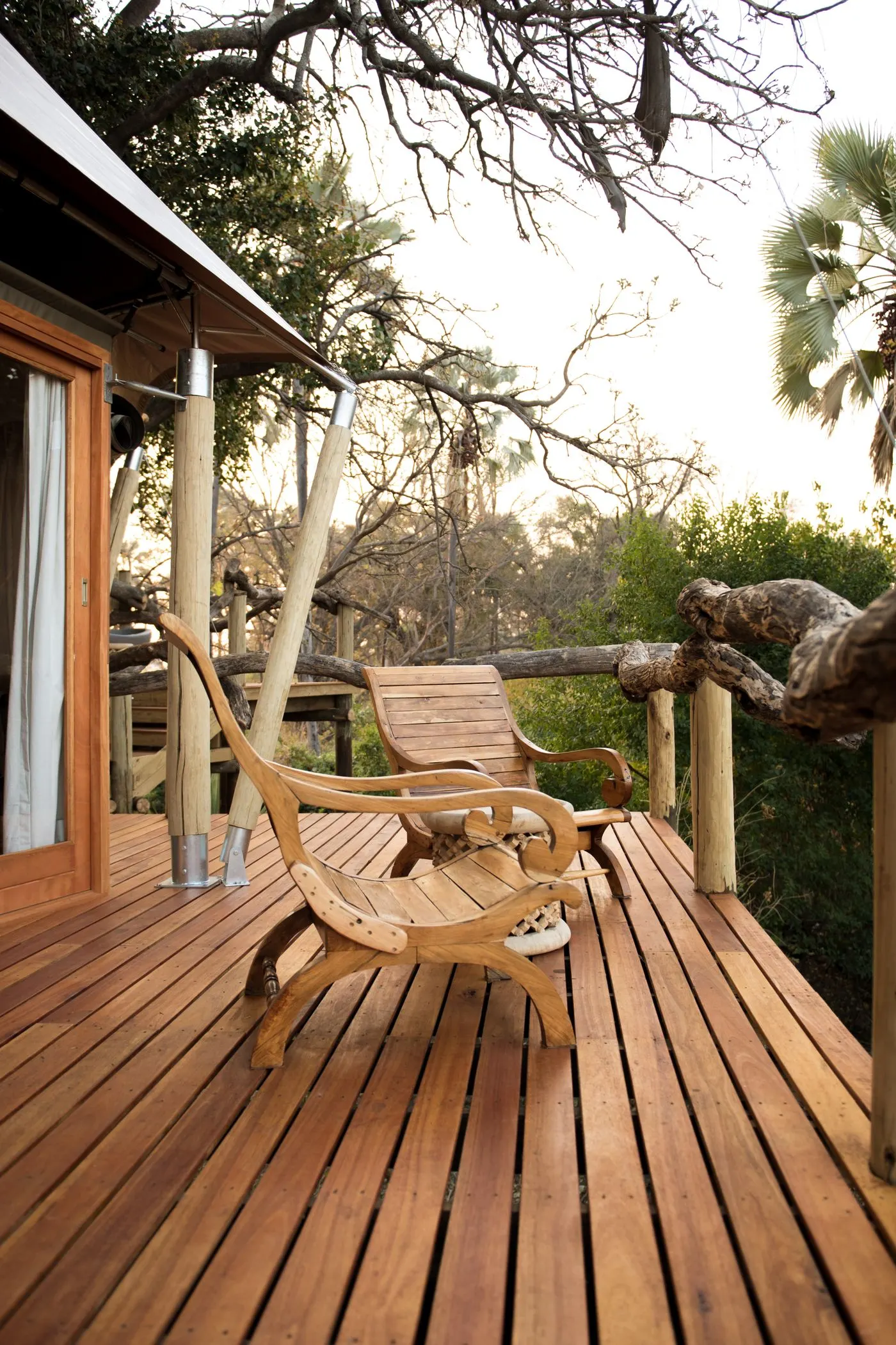 A timber viewing deck with chairs set out above the plains